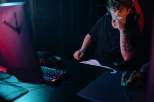 Young man intensely focused on a gaming session at night, highlighting the competitive esports atmosphere.